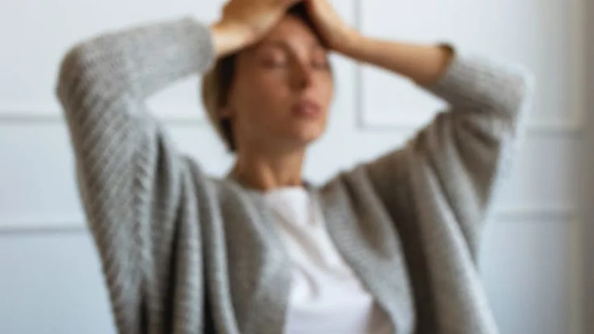 Mujer sentada con las manos en la cabeza