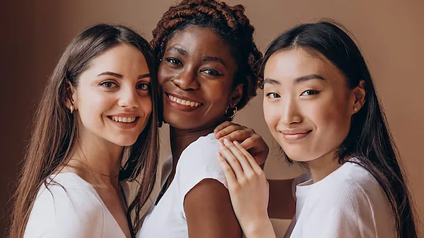 Tres jóvenes de distintos orígenes sonriendo juntas