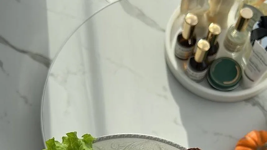Encimera de mármol con una bandeja de botellas y verdura fresca